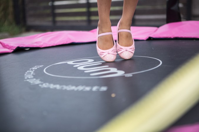 girl in pink shoes on trampoline