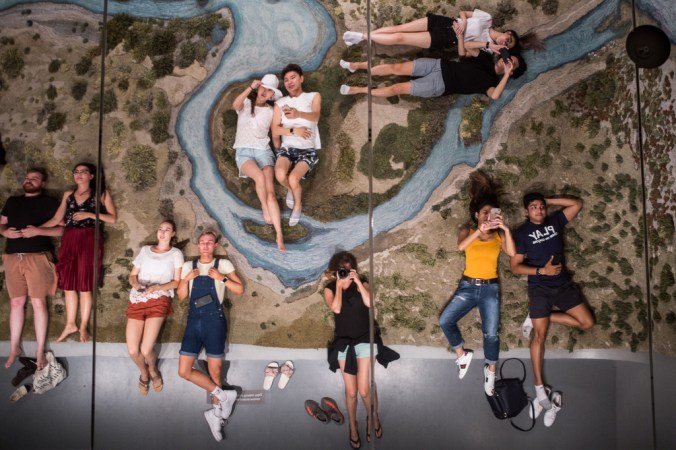 people laying on art looking in mirror